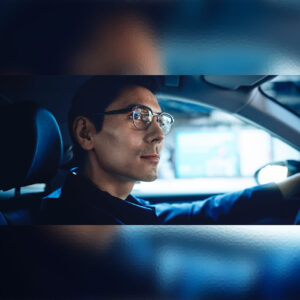 ZEISS - DriveSafe ph1x1 - Άντρας οδηγεί με σιγουριά χαμογελώντας. Φοράει γυαλιά με φακούς ZEISS DriveSafe